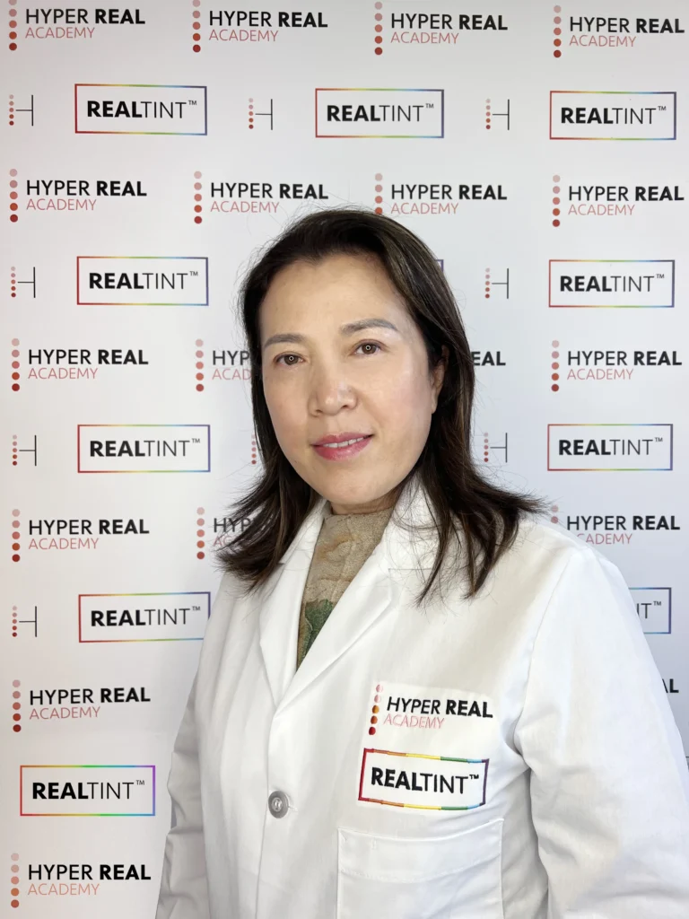 Hyper Real Academy PMU training instructor Anna in RealTint lab coat at permanent makeup demonstration event.