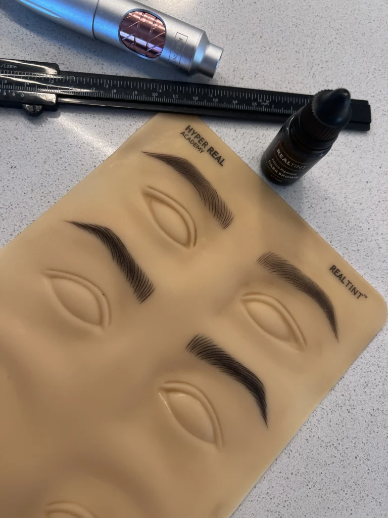 Hyper Real Academy PMU training pad with RealTint pigment showing nano brows and hair strokes demonstration.