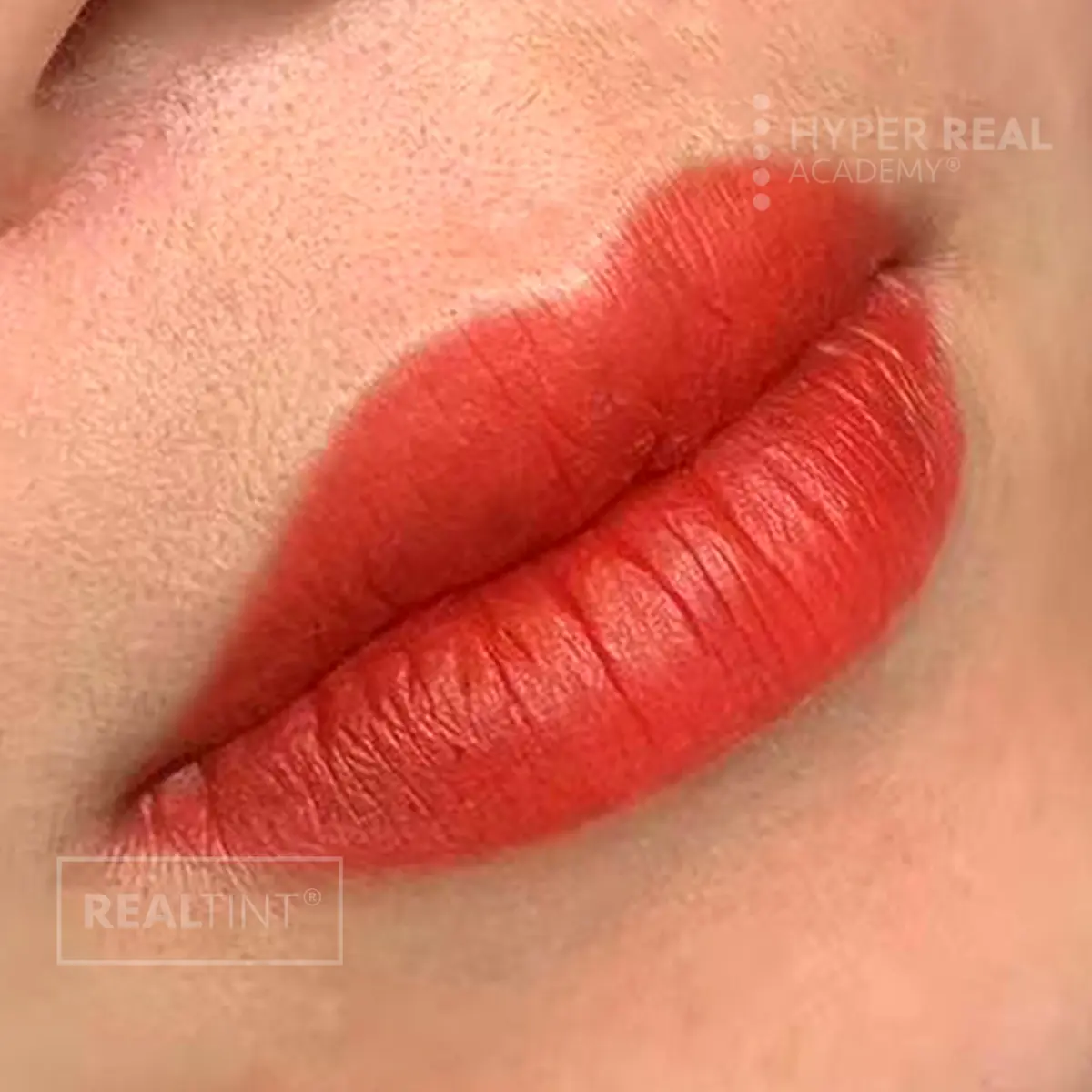 Lip blush PMU close-up with rosy-pink enhanced lips on medium-dark skin tone. Slight gloss from healing ointment. Watermarks 'HYPER REAL' and 'PERMANENT MAKEUP' visible.