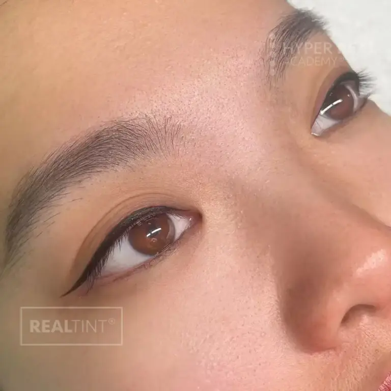 Close-up portrait showcasing septum piercing and well-defined eyebrows. Watermarks 'MEAN' and 'BEAUTY REAL' visible. Likely promotional photo for piercing or brow services.