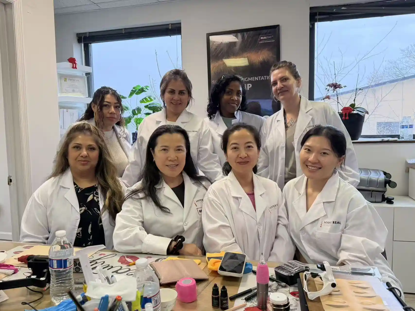 PMU students in Hyper Real lab coats pose with training equipment after a hands-on class