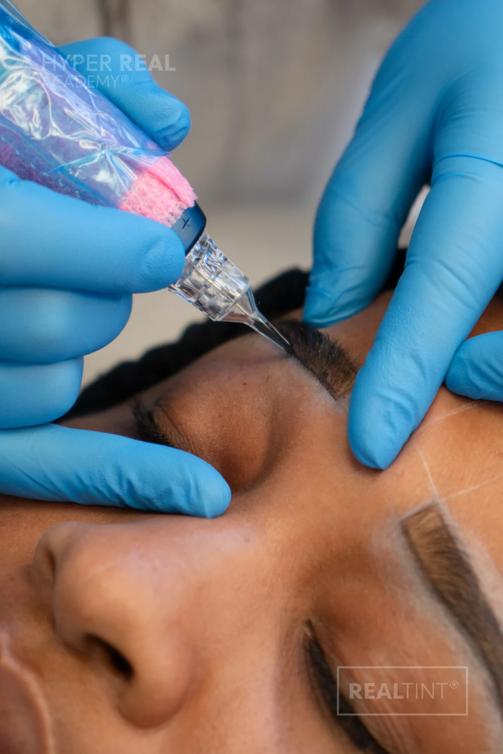 Close-up of machine brow work with a RealTint pen and pre-mapped brow outline on a client at Hyper Real Academy
